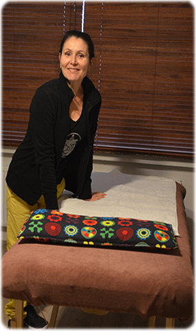 op deze foto zien we collega masseuse Karla Fernandes naast een massagetafel in haar praktijk